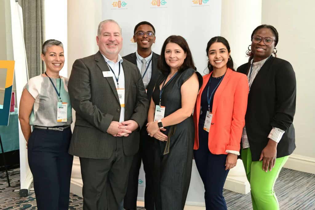 Photo of the six members of Team NLC, a diverse group of men and women, smiling into the camera