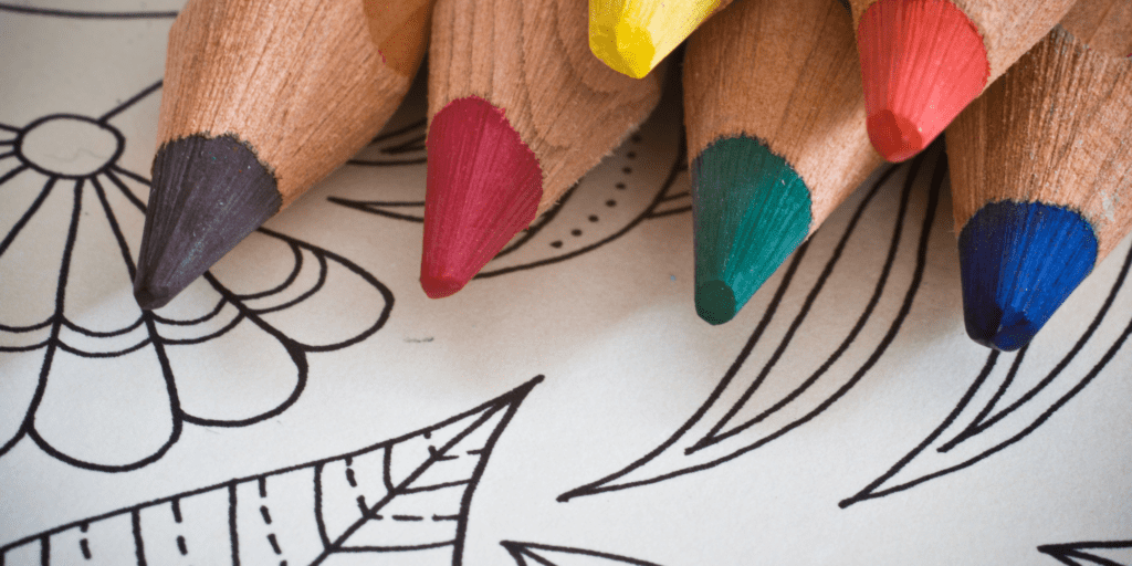 Coloring pages for nonprofit leaders: Set of six colored pencils laying on top of a blank coloring page