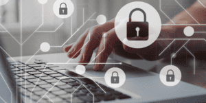 A partial image of a laptop and a persons hand white with white images of locks across the screen