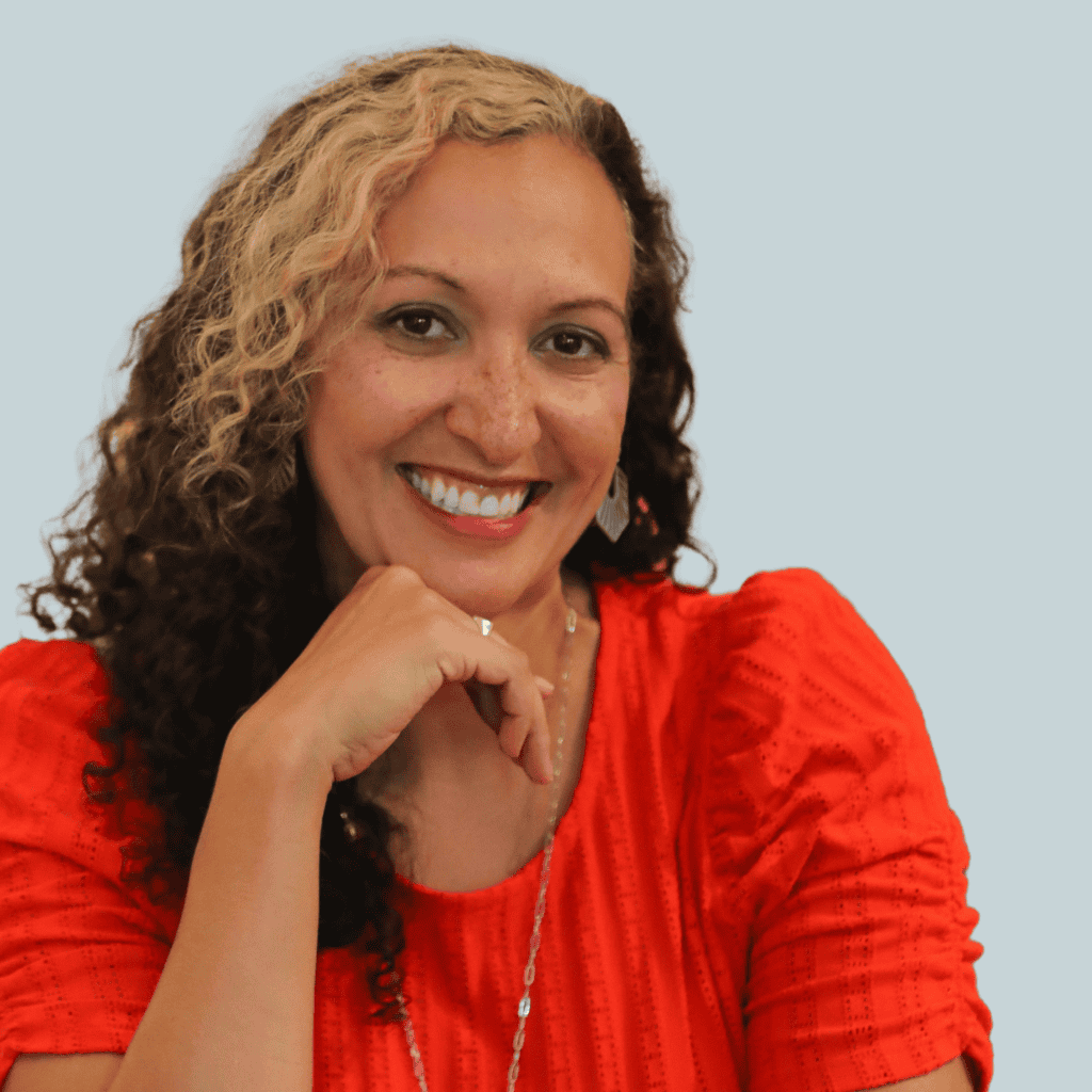 Headshot of Dawn Hunter, a white woman with blonde and brown hair wearing a bright orange top and smiling into the camera