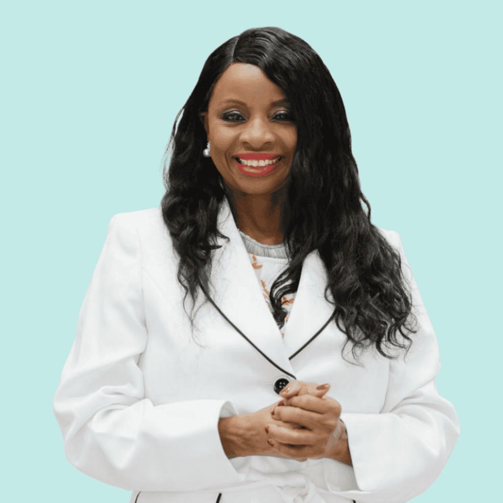 Photo of DrStem, a Black woman with long black hair wearing a white suit jacket against a light blue background