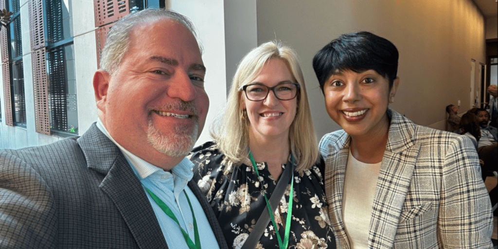 Photo of Charlie Imbergamo, a white man wearing a grey suit with Leah McDermott and Sabeen Perwaiz