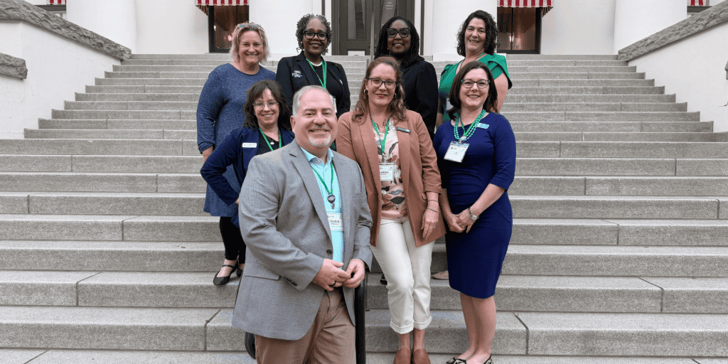 NLC CEO Charlie Imbergamo stands on the Capitol steps next to seven other diverse nonprofit leaders (all women) to advocate for nonprofits and communities