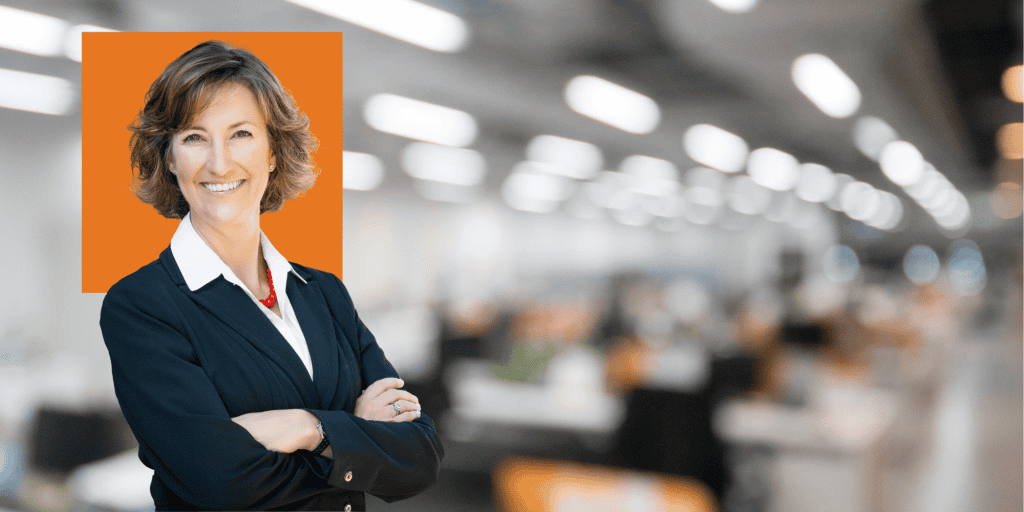 Photo of Jennifer Currence, a white woman with short brown hair wearing a navy suit jacket and white collared shirt in front of a blurred office background