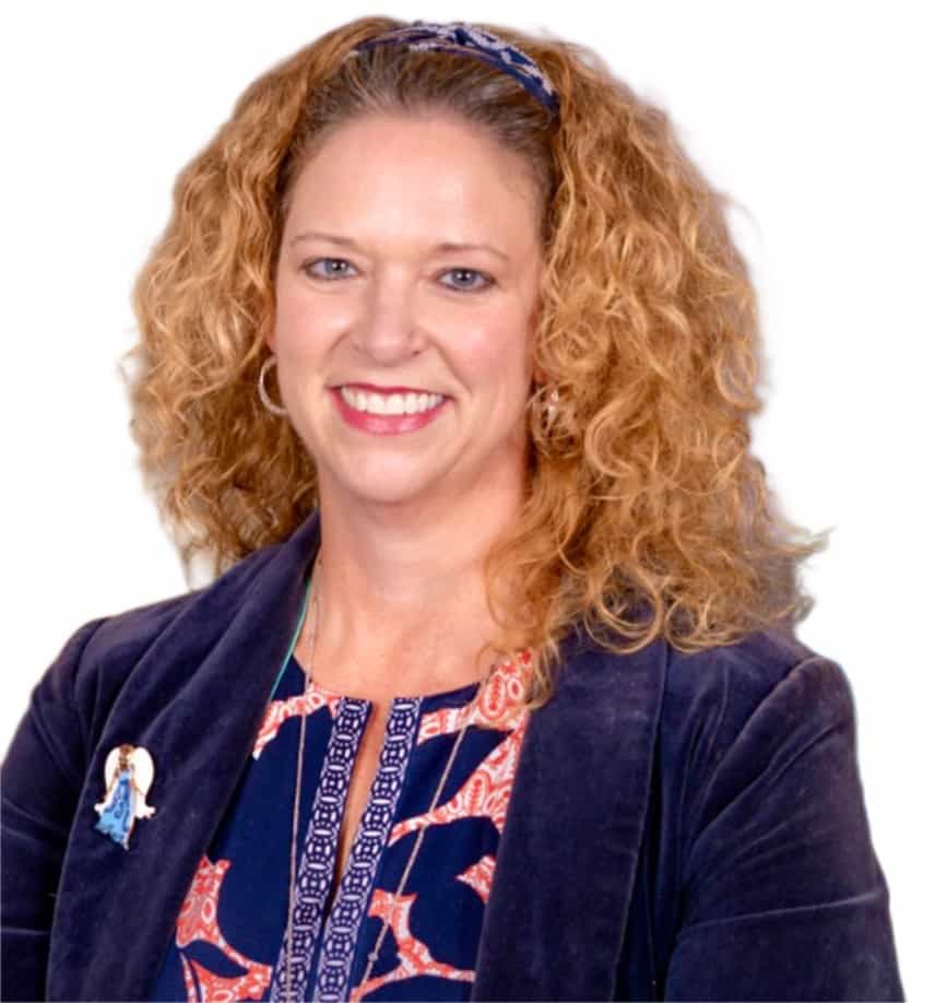 Headshot of Mandy Cloninger, a white woman with reddish brown curly hair wearing a navy suit jacket and matching floral top.