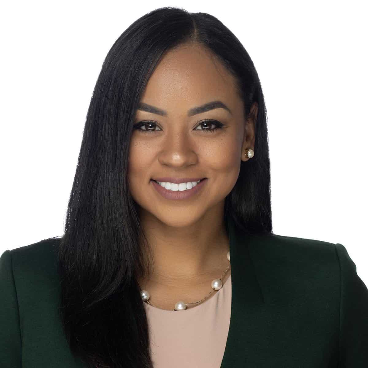 Headshot of Melissa Morin, a woman with dark hair and brown skin wearing a black jacket and tan blouse, smiling at the camera.