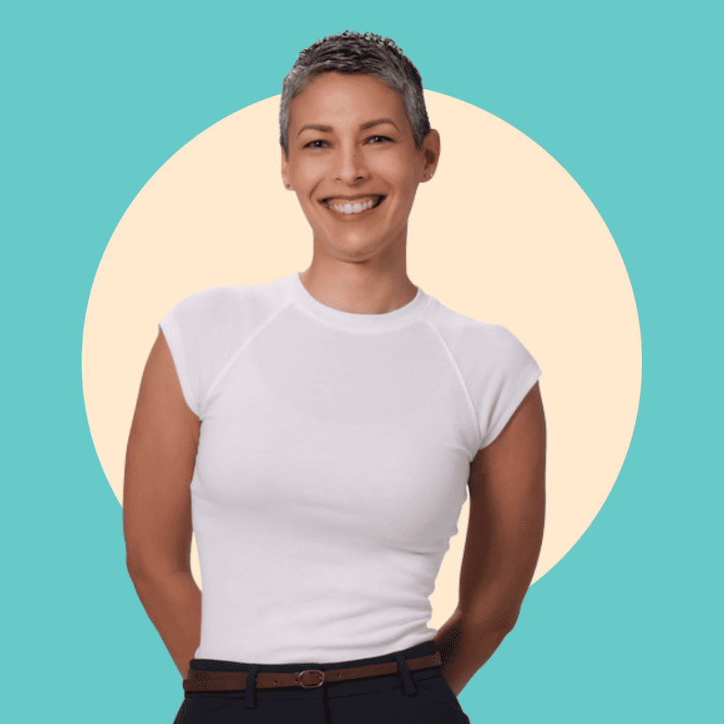 A Puerto Rican woman with short grey hair wearing a white T-shirt and smiling with a blue and yellow background with a circle behind her