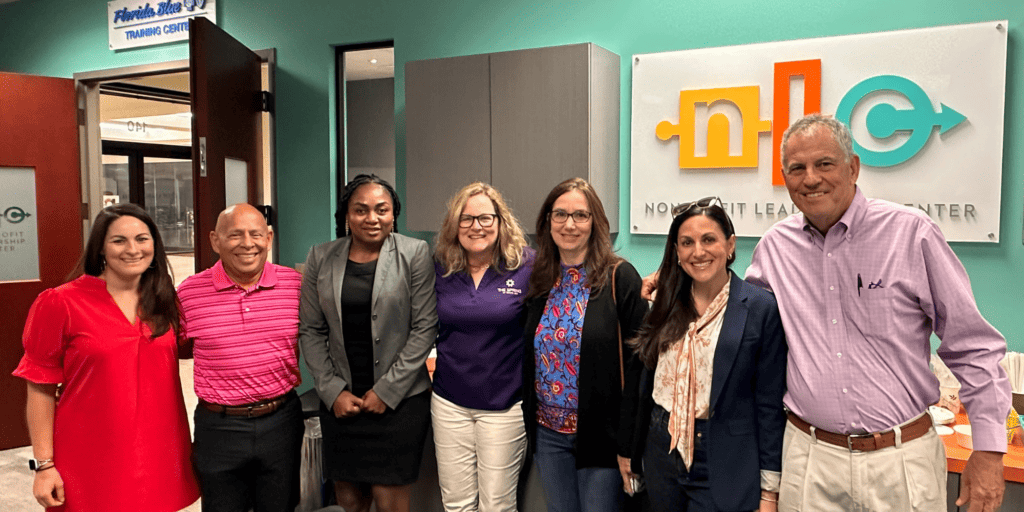 Members of the Nonprofit Leadership Center board smile at the camera, including five women and two men of diverse backgrounds, experiences, races and ethnicities