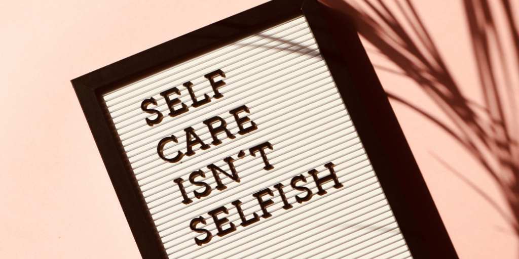 White and black sign that says self care isn't selfish
