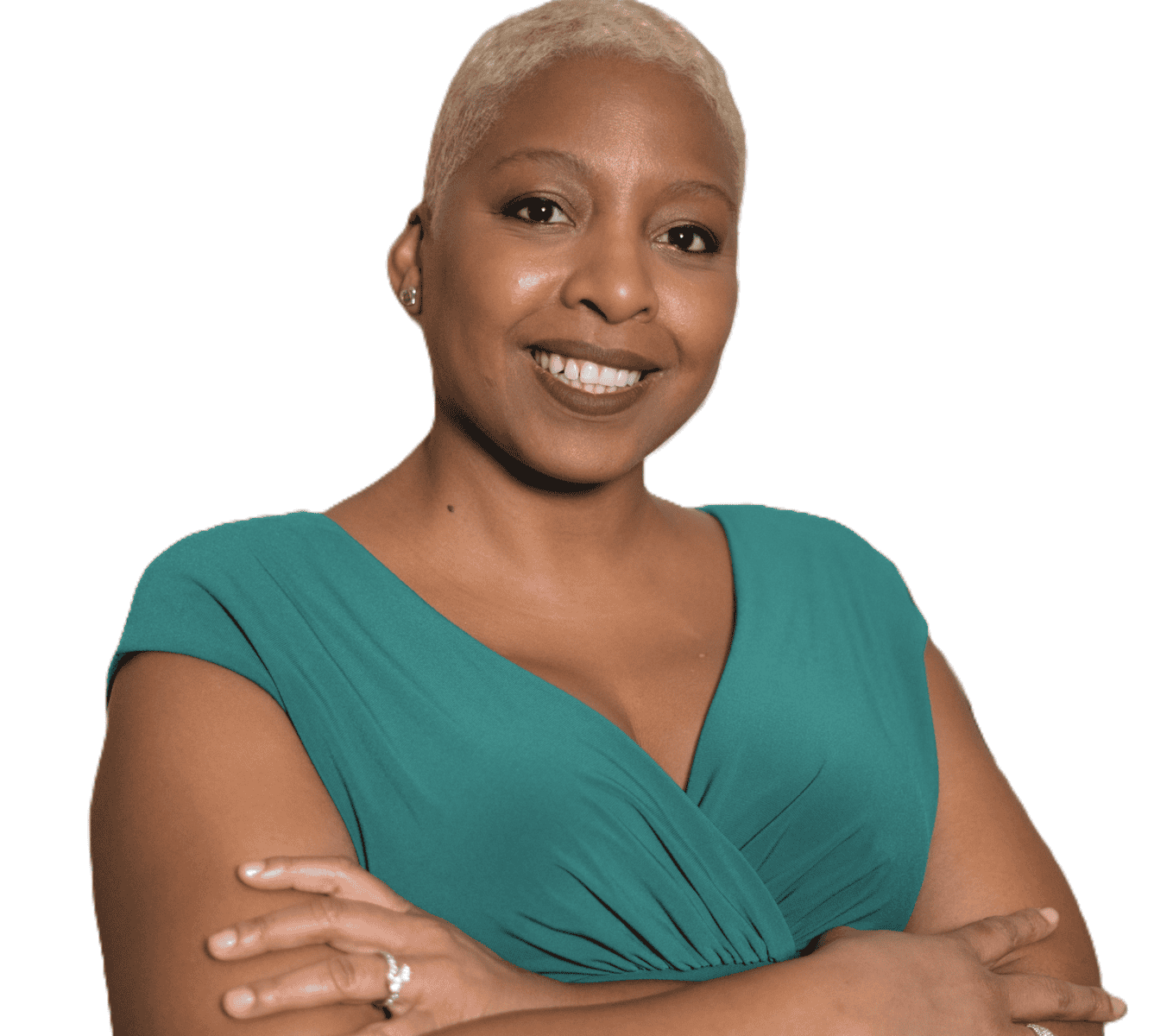 Portrait of a smiling woman with short blonde hair wearing a teal dress arms crossed against a white background