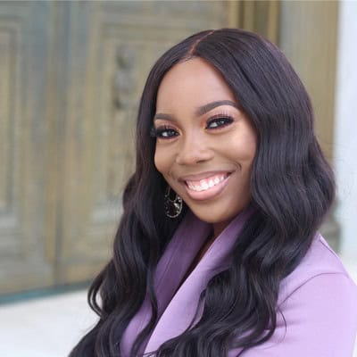 Headshot of Tristan Brown, a Black woman with long black hair wearing a purple suit jacket and smiling into the camera; Tristin is a participant in the 2026 Certificate in Leadership offered by the Nonprofit Leadership Center