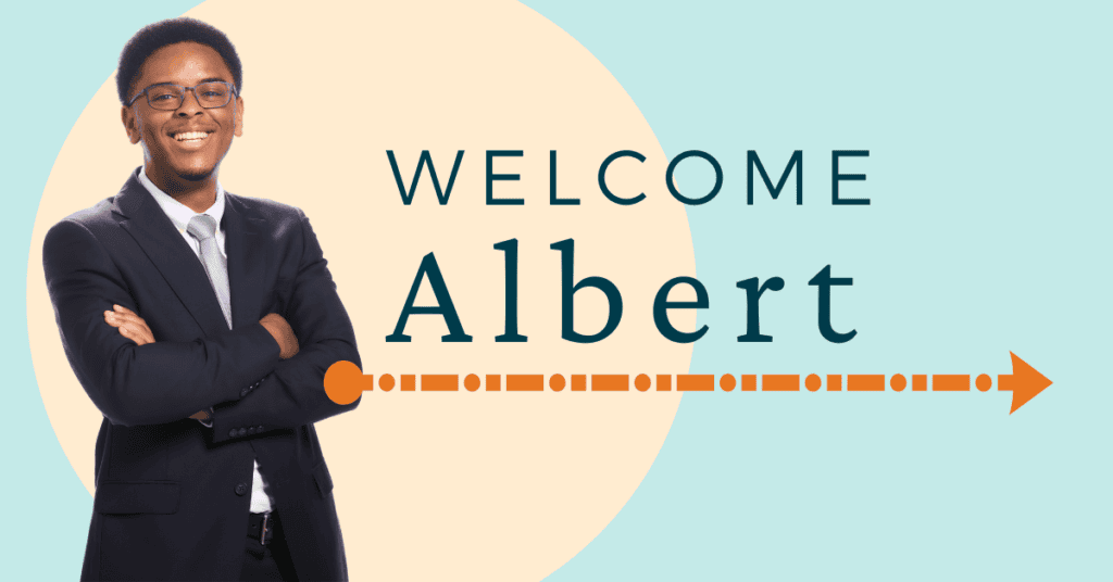 Photo of a young Black man wearing a black suit, white collared shirt and glasses, with his arms crossed smiling into the camera next to the words: Welcome Albert